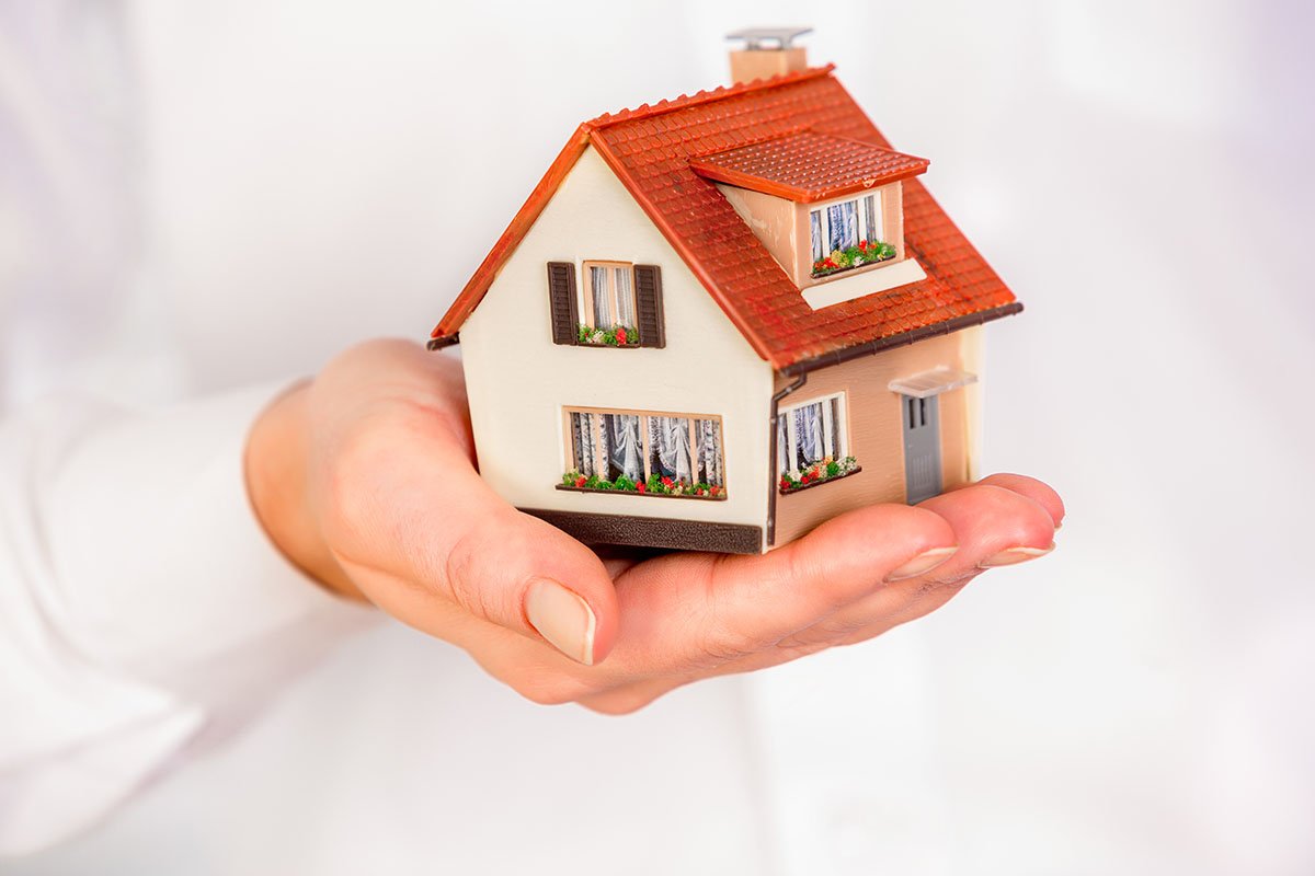 House in human hands on a white background